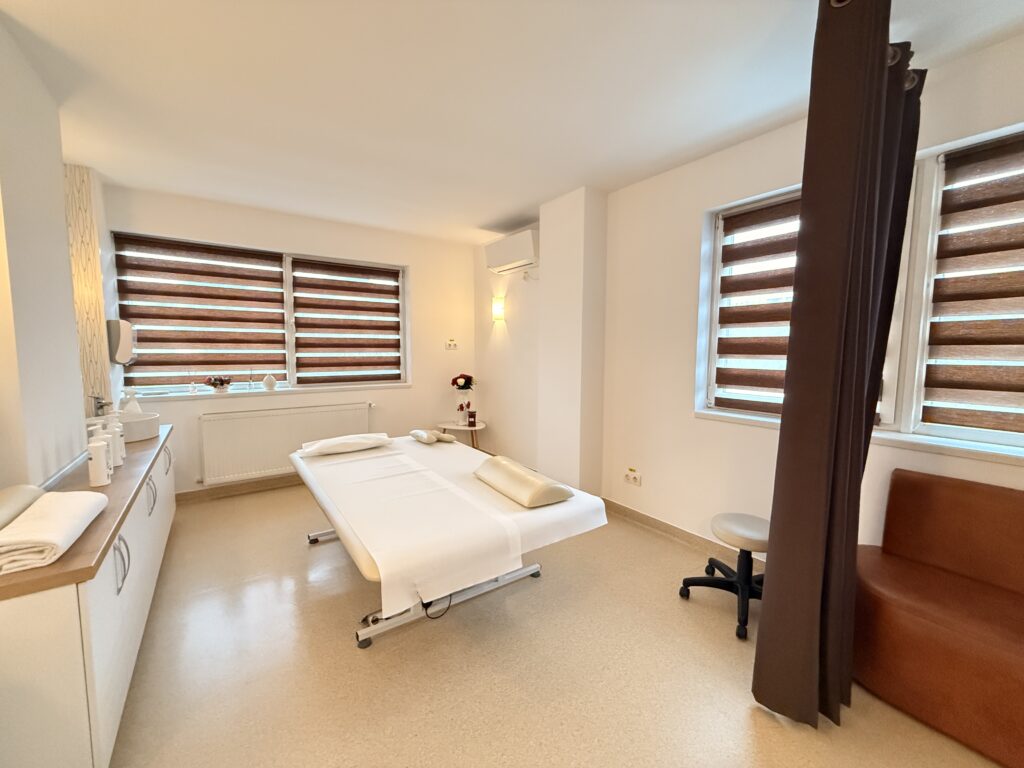 Poză panoramico cu sala de masaj 5, masa de masaj bobath, băncuța pentru zona de schimb a clienților și copertina ce delimitează sala.